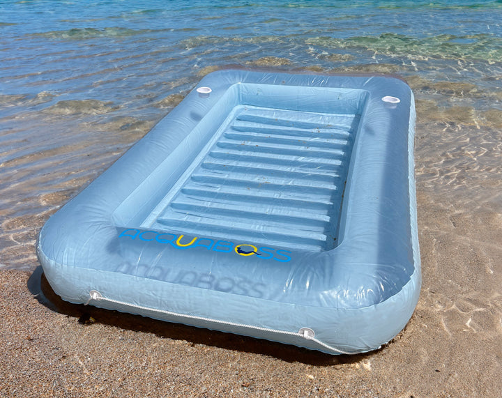 Sun tanning bed lounger at the beach, featuring inflatable pillows, cup holders, and sturdy rope for a comfortable and relaxing beach experience. Perfect for sunbathing and lounging by the water.