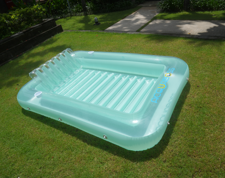 Light green inflatable tanning bed in the backyard with inflatable pillow, drink holders and with a rope